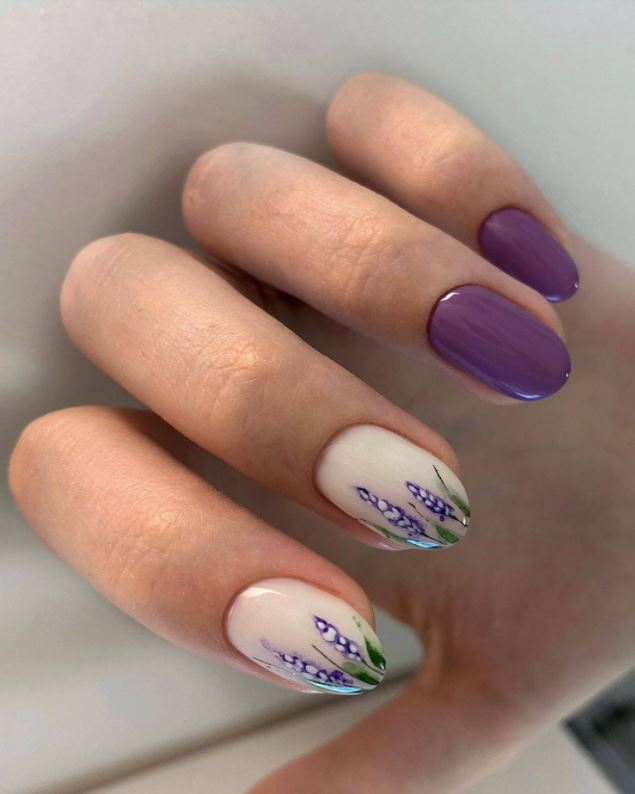 Модний фіолетовий колір на нігтях: відтінок лаванди з квітковим малюнком на двох пальчиках
